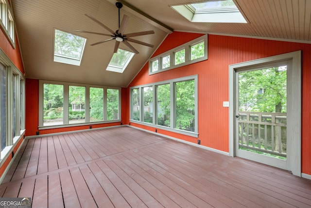 unfurnished sunroom with a deck, lofted ceiling with skylight, wooden walls, and hardwood / wood-style flooring