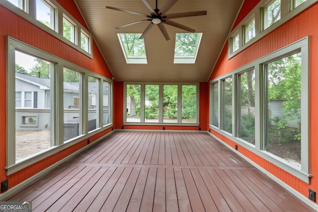 unfurnished sunroom with lofted ceiling with skylight and hardwood / wood-style floors