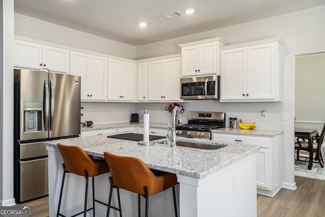 496 River Run Dr, Dallas, GA 30132 - kitchen featuring appliances with stainless steel finishes, white cabinets, an island with sink, and recessed lighting