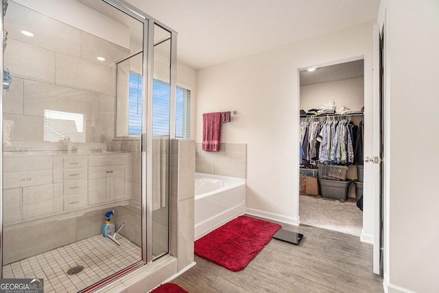 496 River Run Dr, Dallas, GA 30132 - full bath featuring a stall shower, wood finished floors, a bath, and a walk in closet