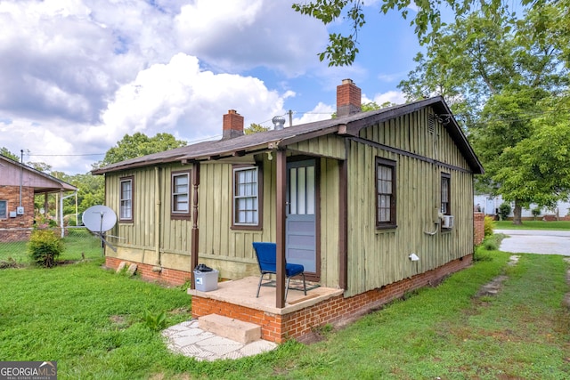 157 Hartwell St, Royston, GA 30662 - back of property with fence, a lawn, board and batten siding, and a chimney