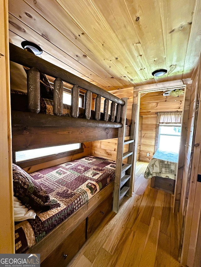 bedroom featuring wood ceiling, wooden walls, and hardwood / wood-style floors