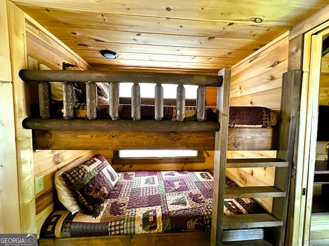 bedroom with wooden ceiling and wood walls