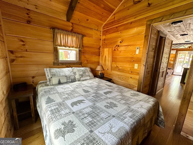 bedroom with wood-type flooring, wood walls, wooden ceiling, and lofted ceiling