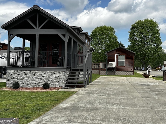 view of front of home with covered porch, a front yard, and faux log siding