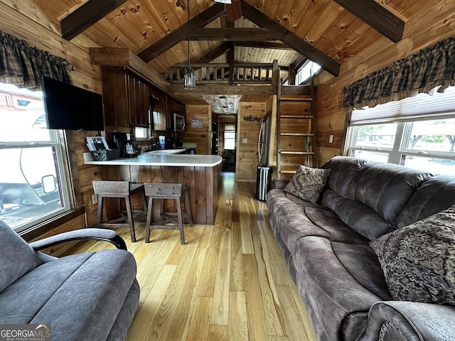 living area featuring wooden ceiling, wood walls, vaulted ceiling with beams, and light wood finished floors