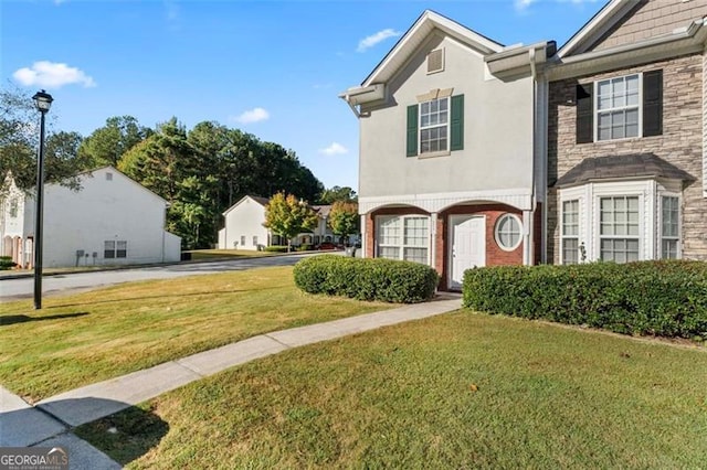 6099 Camden Forrest Cv, Riverdale, GA 30296 - view of front facade featuring a front lawn, brick siding, and stucco siding