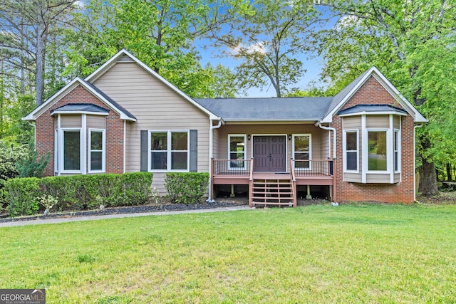 back of house featuring a lawn, brick siding, and a wooden deck