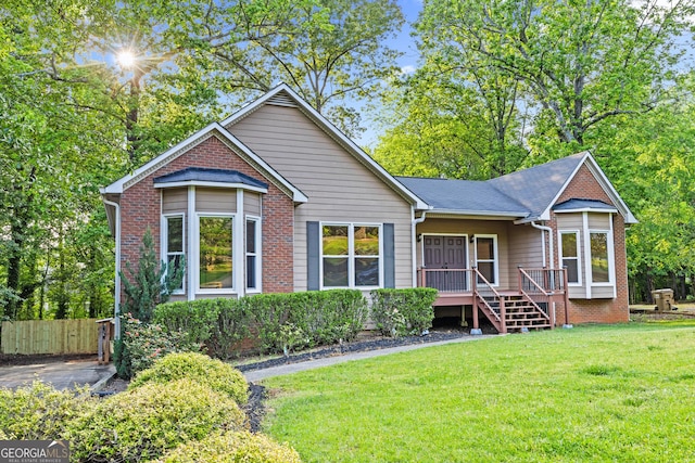 view of front of property with brick siding, fence, and a front lawn
