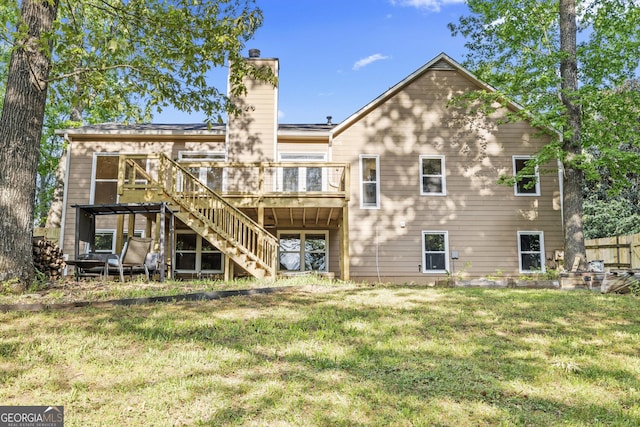 back of property with stairway, a lawn, a wooden deck, and a chimney