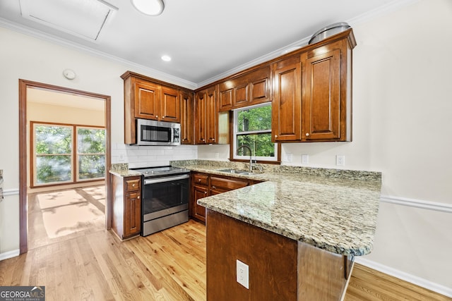 4805 Forest Way Ct NE, Marietta, GA 30066 - kitchen with appliances with stainless steel finishes, light stone countertops, light wood finished floors, a peninsula, and plenty of natural light