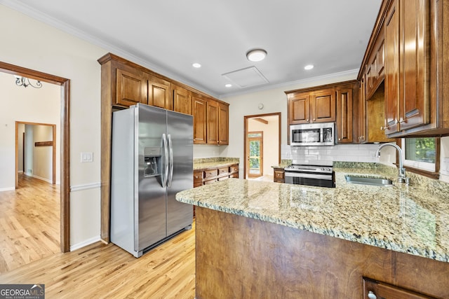 4805 Forest Way Ct NE, Marietta, GA 30066 - kitchen featuring stainless steel appliances, light wood finished floors, ornamental molding, a peninsula, and light stone counters