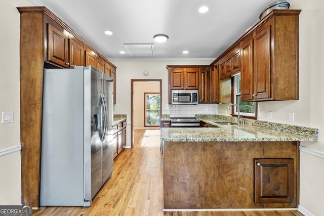 4805 Forest Way Ct NE, Marietta, GA 30066 - kitchen featuring appliances with stainless steel finishes, a peninsula, healthy amount of natural light, light stone countertops, and recessed lighting
