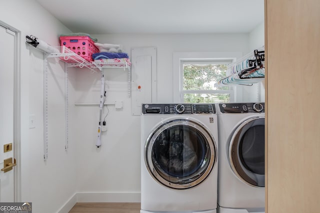 laundry room featuring baseboards, laundry area, wood finished floors, and washing machine and clothes dryer
