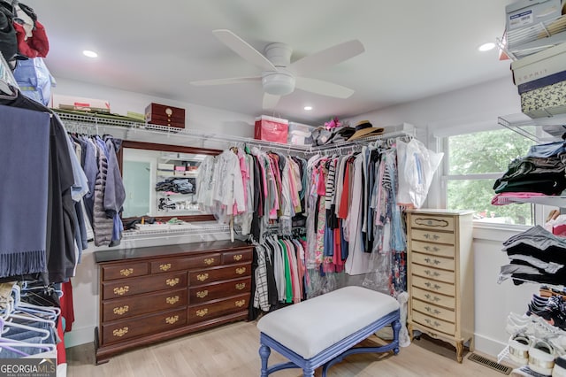 spacious closet with ceiling fan, wood finished floors, and visible vents
