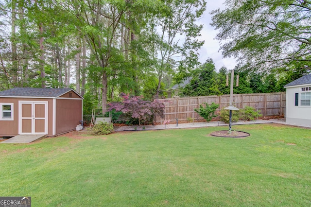 view of yard with a fenced backyard, an outdoor structure, and a storage shed