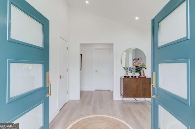 foyer entrance with recessed lighting, light wood finished floors, and lofted ceiling