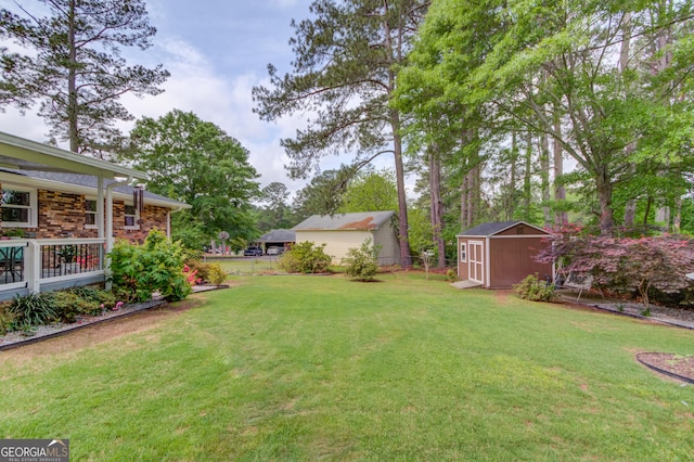 view of yard featuring fence, a storage unit, and an outdoor structure