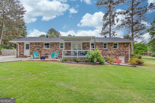 back of property featuring a yard, an attached garage, fence, and a patio area