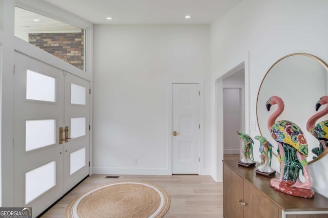 entrance foyer featuring recessed lighting, baseboards, french doors, and light wood-style floors