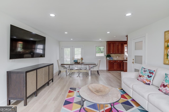 living room with recessed lighting, light wood-style flooring, and baseboards