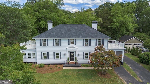 6104 Floyd St NE, Covington, GA 30014 - colonial house featuring a chimney, a balcony, and a front lawn