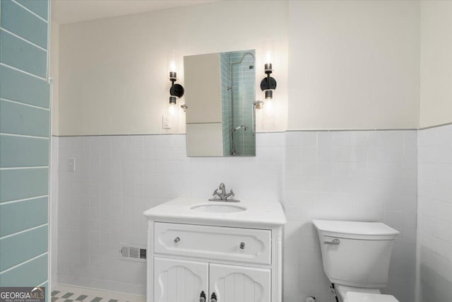 6104 Floyd St NE, Covington, GA 30014 - bathroom with tile walls, toilet, vanity, and a wainscoted wall