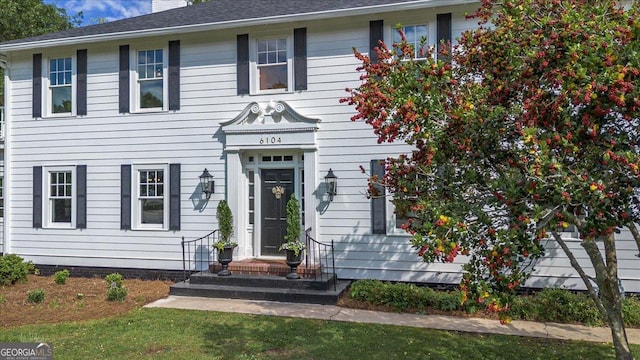 6104 Floyd St NE, Covington, GA 30014 - colonial inspired home with a chimney, a front lawn, and a shingled roof