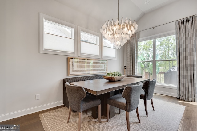 dining room with baseboards, a chandelier, wood finished floors, and lofted ceiling
