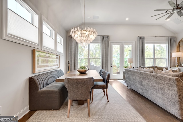 dining area with baseboards, french doors, dark wood finished floors, ceiling fan with notable chandelier, and vaulted ceiling