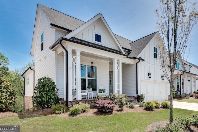 modern inspired farmhouse featuring a porch, an attached garage, board and batten siding, and concrete driveway