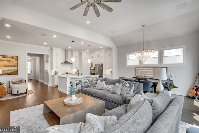 living room featuring baseboards, ceiling fan with notable chandelier, and dark wood finished floors
