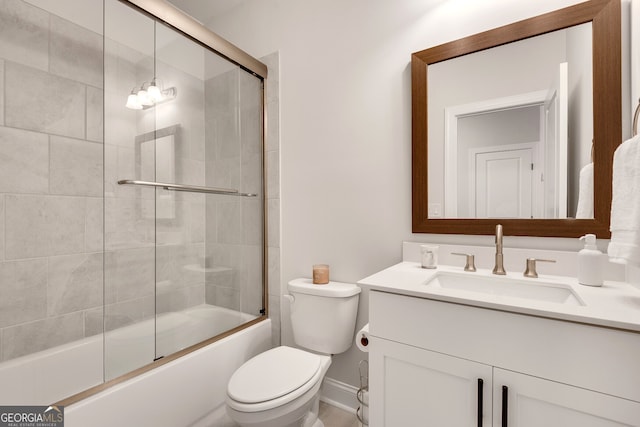 bathroom featuring toilet, baseboards, bath / shower combo with glass door, and vanity