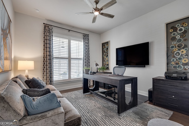 office space with baseboards, ceiling fan, and wood finished floors
