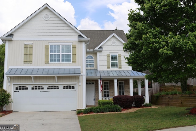 view of front facade featuring a front lawn, a garage, concrete driveway, a standing seam roof, and covered porch