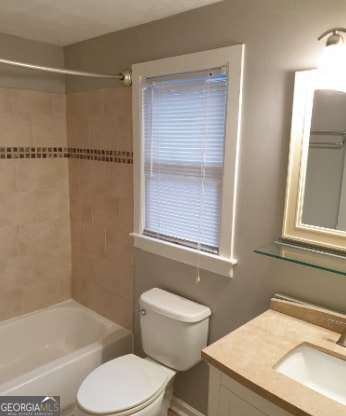 bathroom with vanity, bathtub / shower combination, and toilet