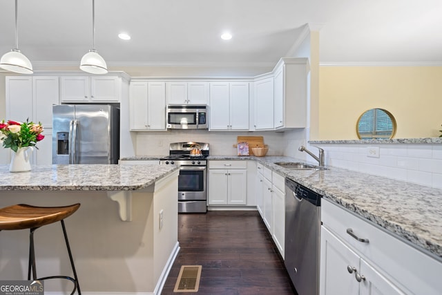 3231 Chutney Ct, Avondale Estates, GA 30002 - kitchen with visible vents, crown molding, appliances with stainless steel finishes, a sink, and a breakfast bar