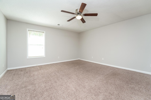 unfurnished room with baseboards, carpet, a ceiling fan, and visible vents