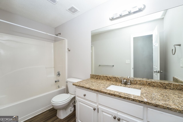 bathroom featuring visible vents, wood finished floors, vanity, toilet, and tub / shower combination