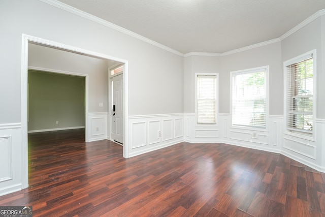 spare room with dark wood-style flooring, ornamental molding, and a wainscoted wall
