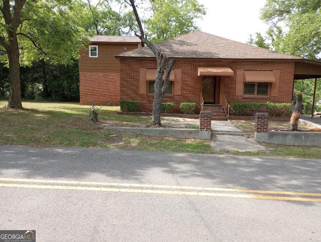 305 Wolfe St, Dublin, GA 31021 - view of front of house featuring roof with shingles, an attached carport, and brick siding