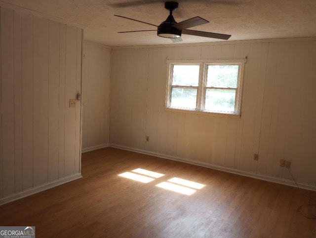 unfurnished room with baseboards, ceiling fan, and wood finished floors
