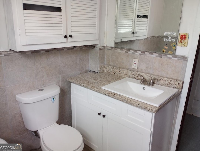 bathroom featuring tile walls, backsplash, vanity, and toilet