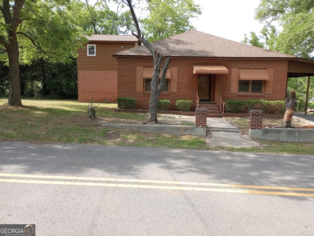 view of front of property with brick siding and roof with shingles