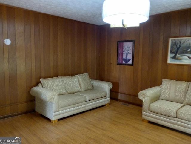 living room featuring wood walls and light wood-style flooring