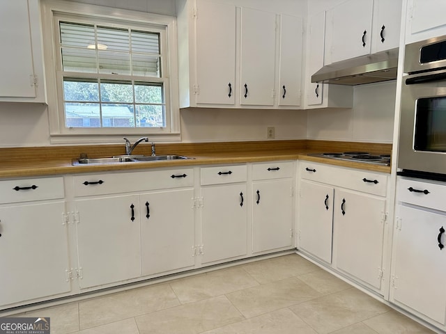111 Howard St, Byron, GA 31008 - kitchen featuring under cabinet range hood, white cabinetry, appliances with stainless steel finishes, and a sink