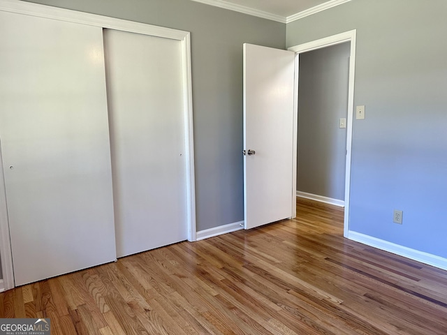 111 Howard St, Byron, GA 31008 - unfurnished bedroom featuring baseboards, ornamental molding, wood finished floors, and a closet