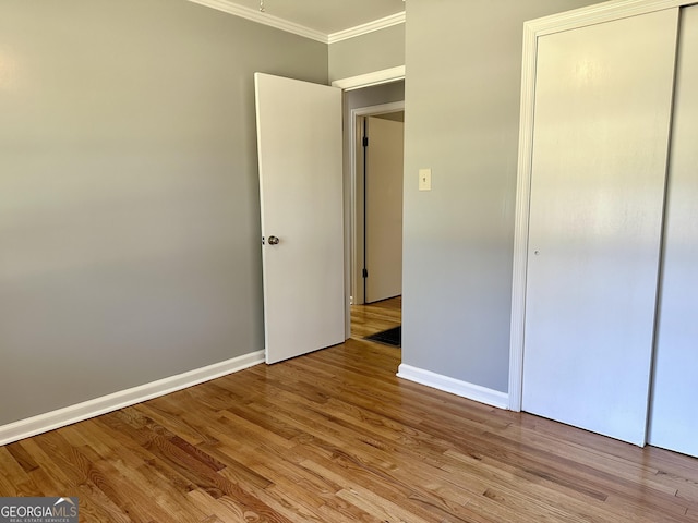 111 Howard St, Byron, GA 31008 - unfurnished bedroom with crown molding, baseboards, light wood-style floors, and a closet