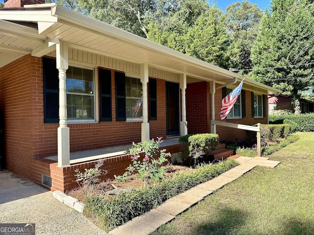 111 Howard St, Byron, GA 31008 - view of front facade featuring a porch, brick siding, and a front lawn
