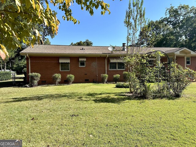 111 Howard St, Byron, GA 31008 - rear view of house with a yard, brick siding, and crawl space